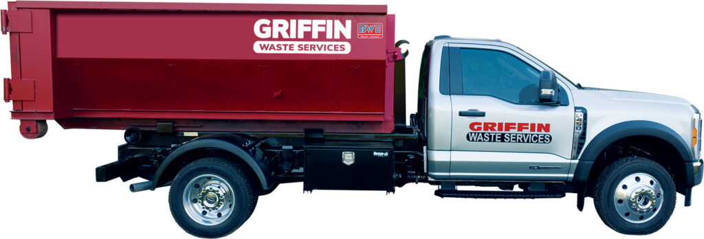 Side view of a white truck with a large red dumpster attached. The truck and dumpster display the text Griffin Waste Services. The truck is parked on a plain background.